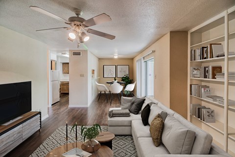 a living room with a couch and a coffee table in front of a tv at Village Oaks Apartments, Austin, Texas 